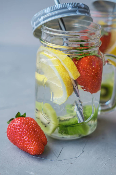Fruit water with lemon and strawberries in a glass jar - Foto, Imagen