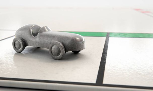 Un primer plano de un metal morir icono del coche fundido en un tablero de juego - 3D render
 - Foto, imagen