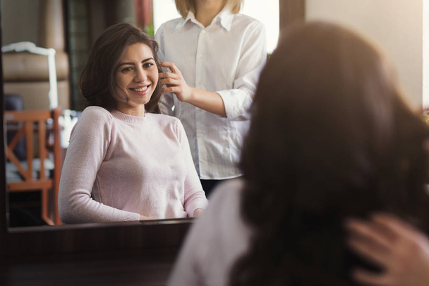 Счастливая красивая женщина обсуждает прическу со своим парикмахером
 - Фото, изображение