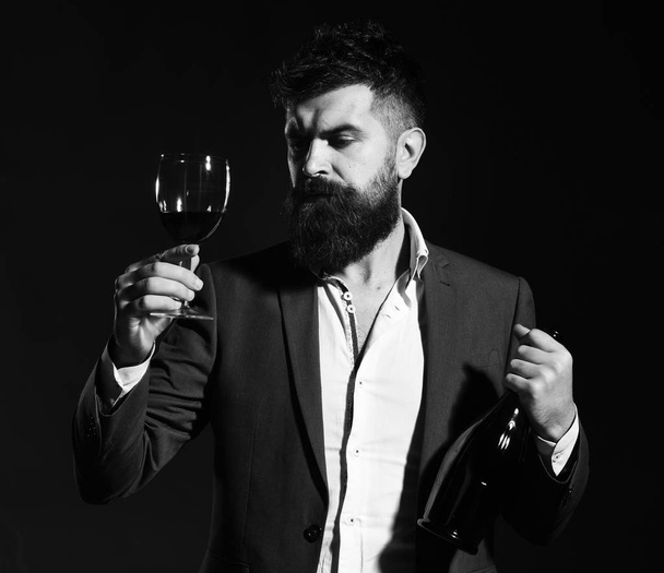 Winetasting and degustation concept. Degustator with beard and expensive alcohol on emerald background - Foto, Bild
