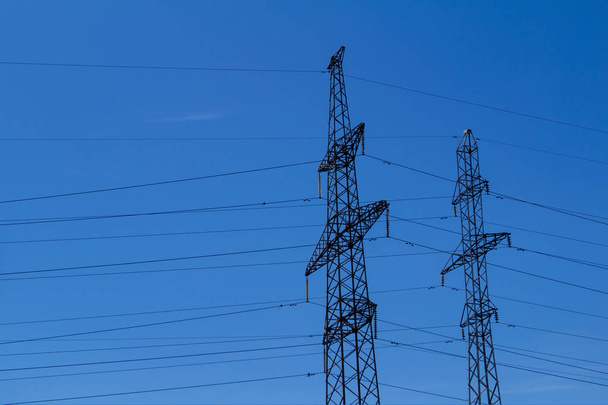 Torre eléctrica de alto voltaje con línea eléctrica contra nubes cielo azul
 - Foto, imagen
