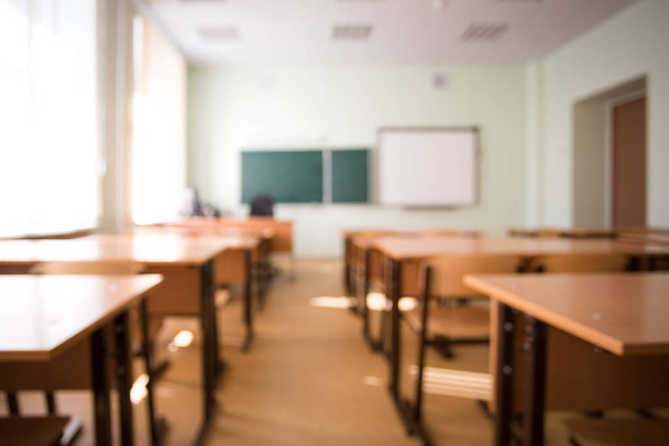 School classroom in blur background without young student. Blurry view of class room no kid or teacher with chairs and tables in campus. - 写真・画像