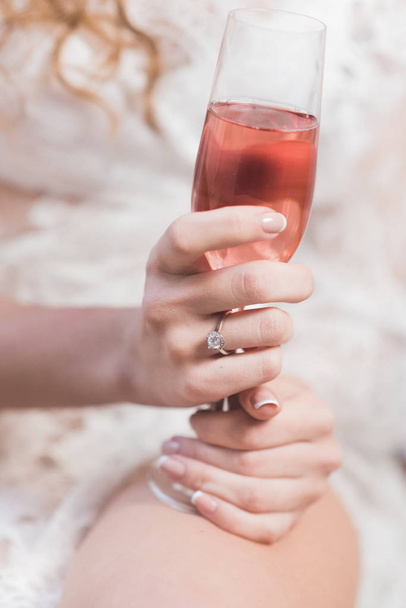 Bride beautiful hands holding a glass of pink champagne - Photo, Image