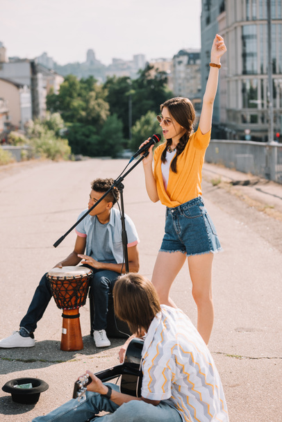 Молодые счастливые мужчины и женщины-уличные музыканты играют музыку на городской улице
 - Фото, изображение