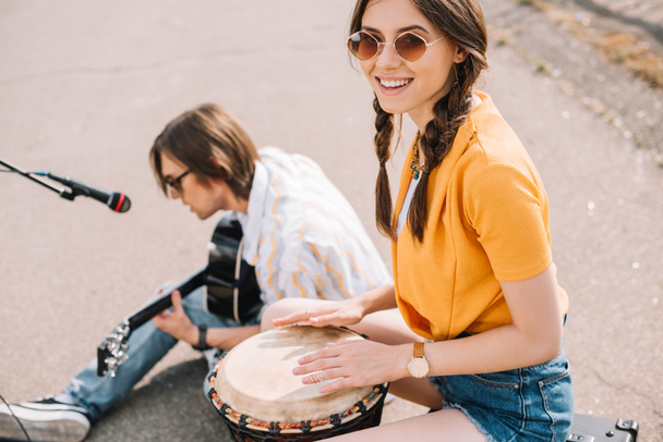 Pár fiatal utcai zenészek, mosolyogva, és előadás-ban városi környezet - Fotó, kép