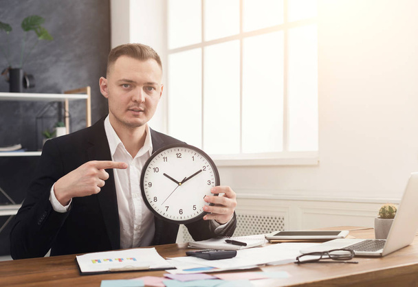 Podnikatel, drží hodiny a poukáže na to - Fotografie, Obrázek