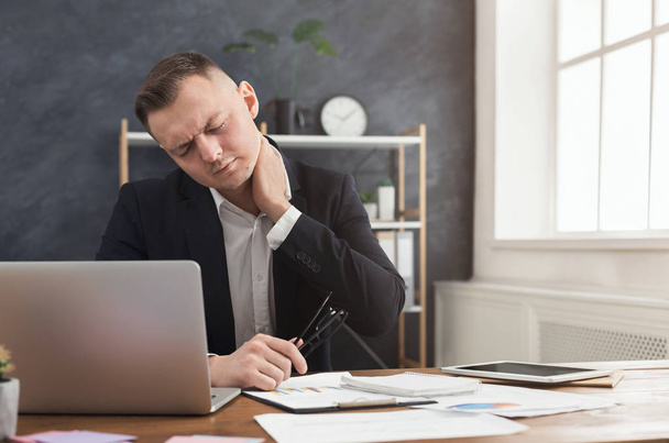 Businessman with neck pain after long hours at work - Photo, Image