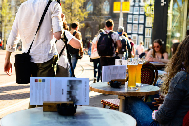 girls drinking cold light beer in street cafe in Amsterdam - Fotografie, Obrázek