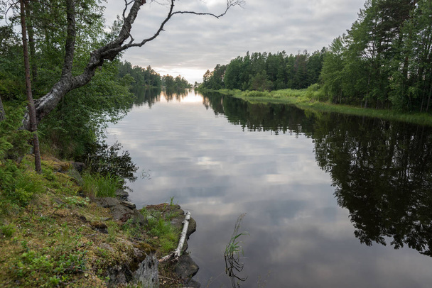 Gyönyörű táj kilátással az erdőre és a víz felszínén, a tó. Ének egy kényelmes és csendes darab föld, sziklás partjait a buja vizei Ladoga-tó fölé emelkedik - Fotó, kép