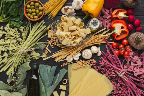 イタリアのパスタとダークブラウンの木製の野菜を混合、トップ ビュー - 写真・画像