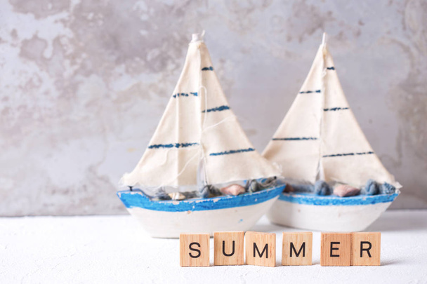 Summer concept. Decorative boats and  word summer written on wooden blocks. Selective focus.  - Foto, afbeelding