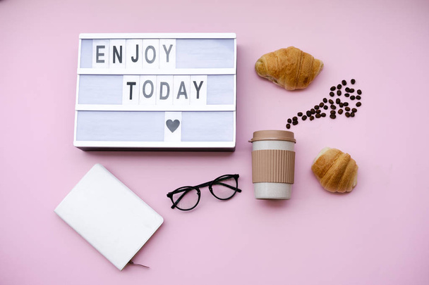 Briefkasten Zitat mit Kaffee und Croissant auf rosa Hintergrund. flache Lage, Stilllebenkonzept von oben - Foto, Bild