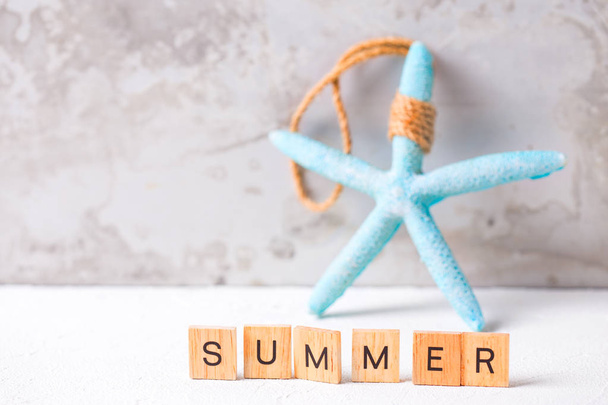 Summer background.  Sea star and wooden blocks with letters. Sea objects. Selective focus. Place for text.  - Foto, Imagem