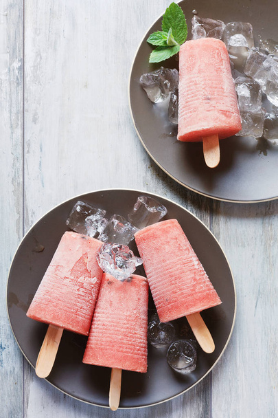 Frozen watermelon sorbet on a plate. Homemade ice cream. Top view, close-up on a light wooden background - Zdjęcie, obraz