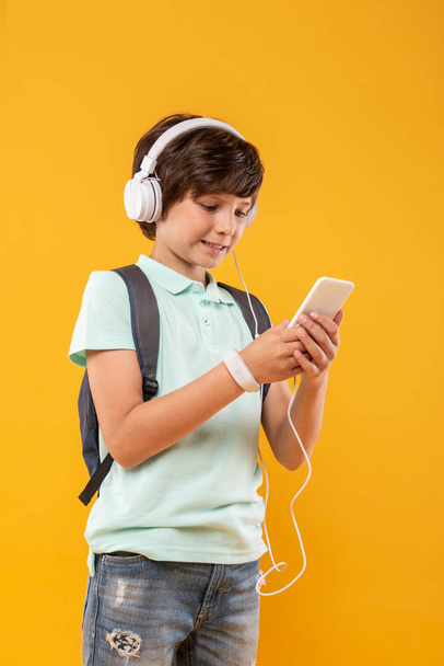 Smiling schoolboy listening to music - Фото, зображення