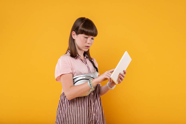 Concentrated girl holding her modern tablet - Zdjęcie, obraz