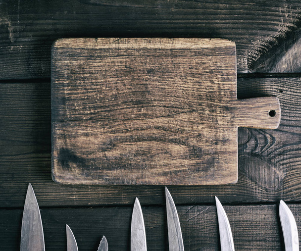 old empty brown rectangular wooden cutting board and knife blade, top view - 写真・画像