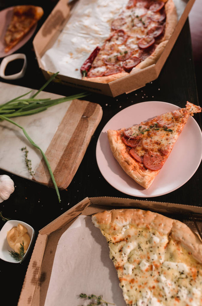 Pizza set on wooden table with bright plates for party. Dark rustic toning food photo. Top view image. - Fotografie, Obrázek