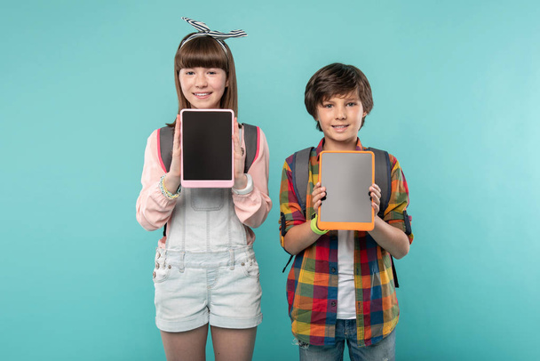 Happy kids showing their tablets - 写真・画像