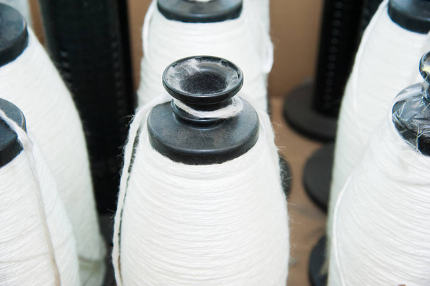 Textilindustrie - Garnspulen auf Spinnmaschine in einer Textilfabrik - Foto, Bild