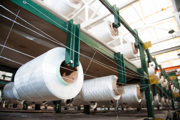 Industria textil - bobinas de hilo en la máquina de hilar en una fábrica textil
 - Foto, imagen