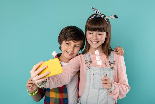 Delighted teenagers taking selfies together - Foto, afbeelding