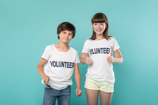 Alerta a los jóvenes voluntarios mostrando pulgares hacia arriba
 - Foto, Imagen