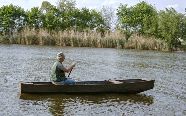 fishing-Fisherman on boat in river - Photo, Image