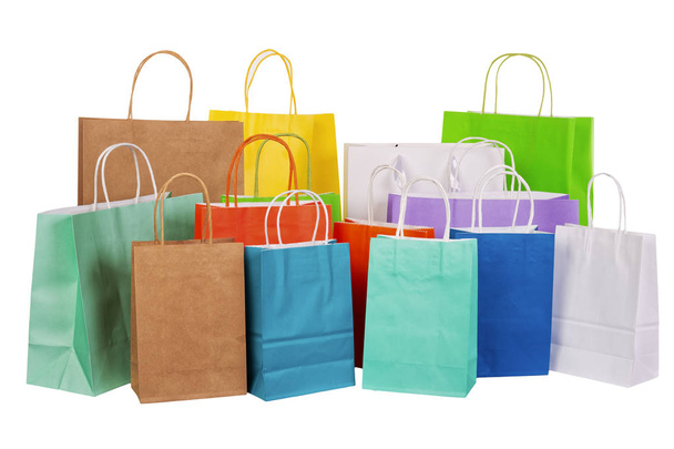 Variety of colored paper shopping bags on white background. Empty area. - Foto, imagen
