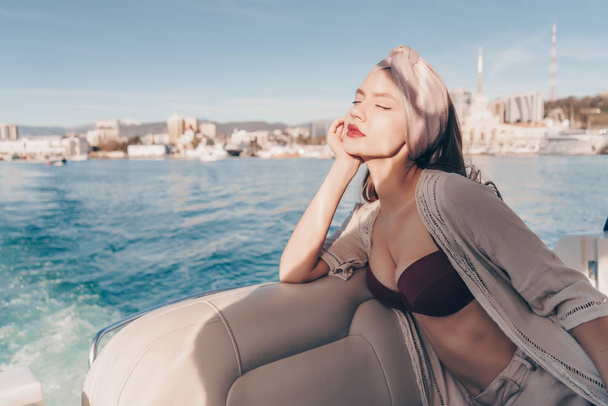 a luxurious beautiful woman enjoys sea voyage and rest on her yacht - Photo, Image