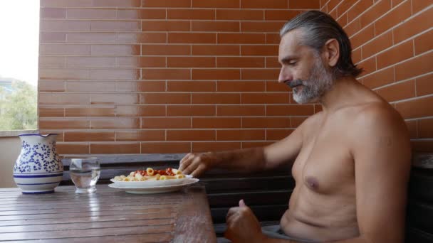 зрелый мужчина без рубашки едят макароны, средиземноморская летняя диета
 - Кадры, видео