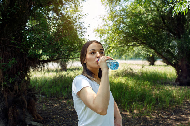 νεαρή γυναίκα με φρέσκο πόσιμο νερό - το υγιεινό νερό - Φωτογραφία, εικόνα