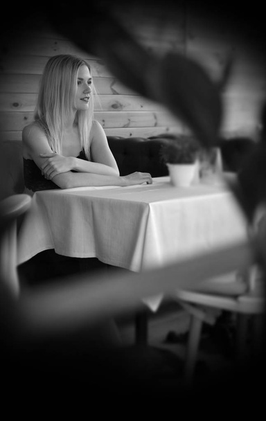 カフェで紫のソファーに座っていた美しい若い女性 - 写真・画像