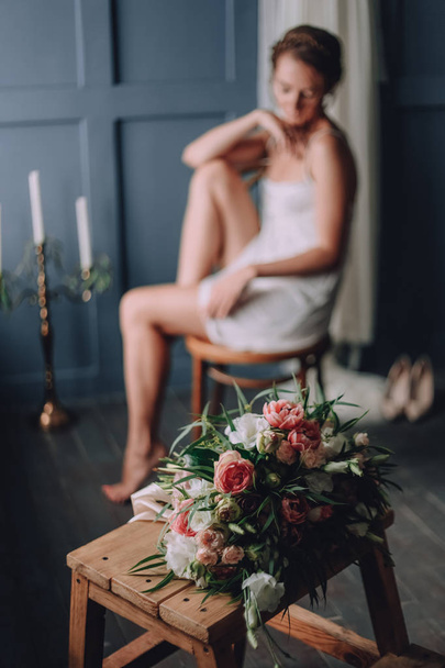bridal bouquet in the morning on a wooden chair and girl with a white dress - Photo, Image