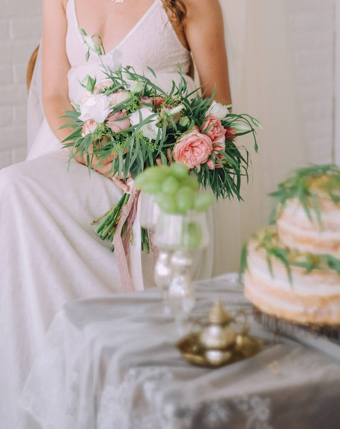 girl with flowers in a room near a table with a cake - Photo, Image