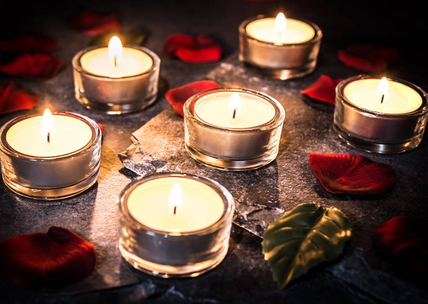 6 lumières romantiques de thé sur l'ardoise avec des pétales et des feuilles de rose
 - Photo, image