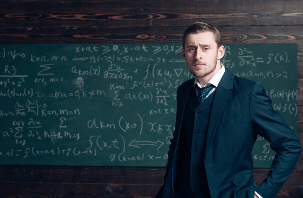 Talented mathematician. Teacher smart student intrested math physics exact sciences. Man formal wear classic suit looks smart, chalkboard with equations background. Genius solved mathematics problem - Photo, Image