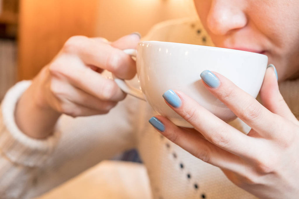 Woman with blue nails drinks  cup of hot coffee. Toned - Foto, Imagem
