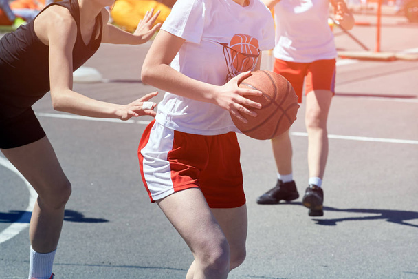 Girls teenagers basketball player play and train on the basketball court in the city on the street. - Foto, Imagem