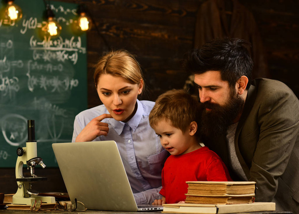 Business tutor typing on laptop at workplace in classroom,Modern teacher hipster writing on big blackboard with math formula, Teachers who become great or master teachers seek out the help they need - Φωτογραφία, εικόνα