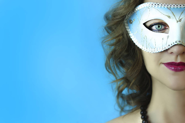 Porträt einer schönen jungen Frau in geheimnisvoller blauer Karnevalsmaske. Mode und Schönheit Foto - Foto, Bild