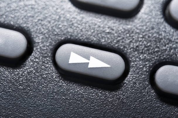 Macro de um botão preto rápido para a frente no controle remoto preto para um sistema de áudio estéreo Hifi
 - Foto, Imagem