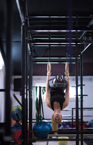 young athletic woman working out on gymnastic rings at the cross fitness gym - Φωτογραφία, εικόνα