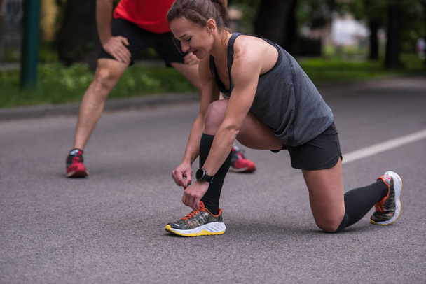 femme attacher des chaussures de course lacets se préparer à courir sur le parc de la ville le matin
 - Photo, image