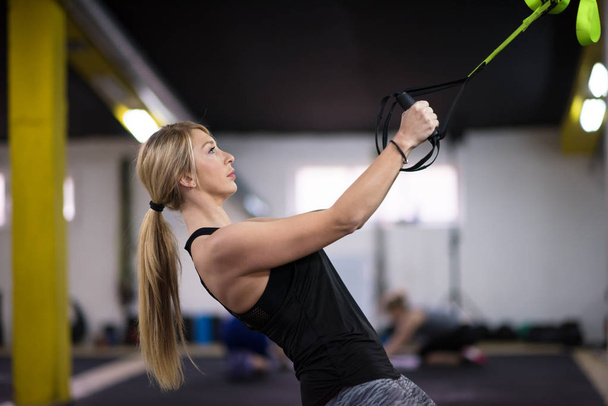 nuori urheilija nainen treenata vetää ups voimistelu renkaat rajat kuntosali
 - Valokuva, kuva