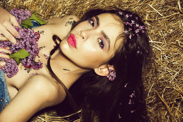 Female fashion concept. young woman with flower in spring, summer on hay background - Fotó, kép