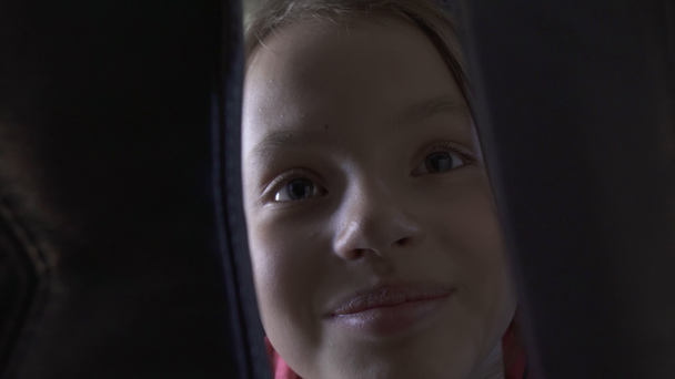 Wesoła dziewczyna nastolatek słucha muzyki na słuchawkach w kabinie samolotu podczas podróży Stockowy materiał wideo - Materiał filmowy, wideo