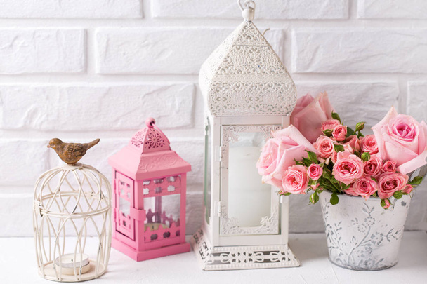 Pink roses  and decorative pink and white lanterns against  white brick wall. Floral still life.  Selective focus. Place for text.  - Foto, immagini