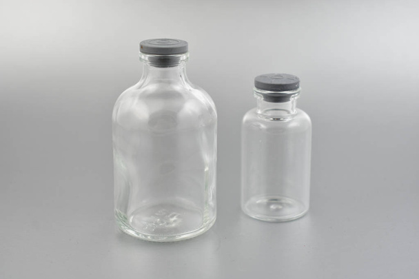 Laboratóriumi üveges üveg stock képek. Üveg fiolába képek. Laboratóriumi üveg ezüst alapon. Laboratóriumi üveg-műanyag dugóval - Fotó, kép
