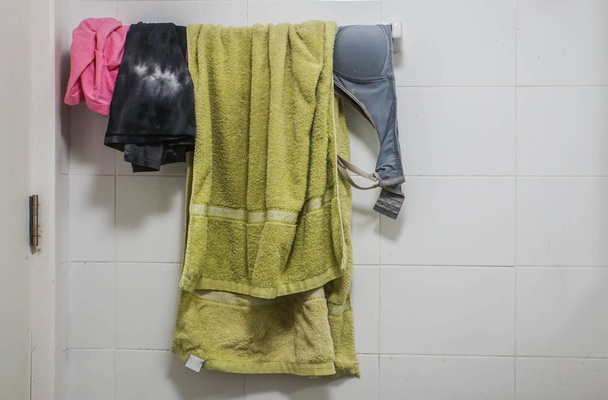 giyim, sütyen ve yeşil havlu raf tuvaletinde asılı üzerinde kapatın - Fotoğraf, Görsel